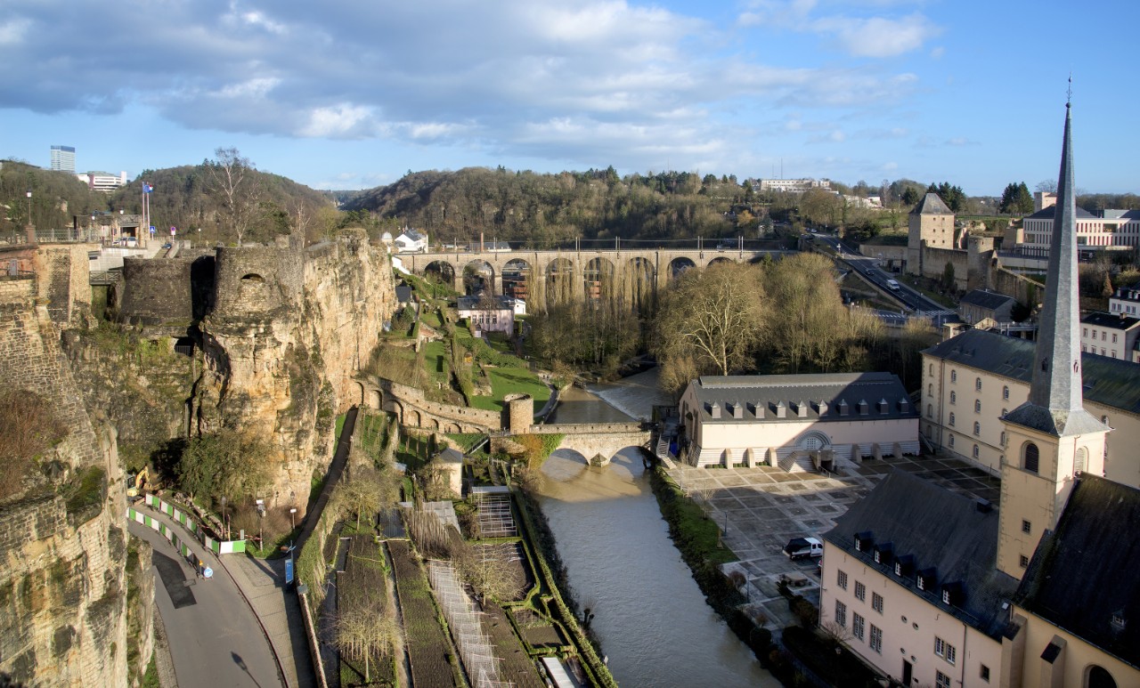 the Alzette River in Luxembourg City, Luxembourg, highlighting the Neumunster Abbey and the Saint-Jean-du-Grund Church on the right and the remains of the fortress in the Bock promontory on the left